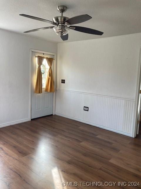 spare room with dark hardwood / wood-style flooring and ceiling fan