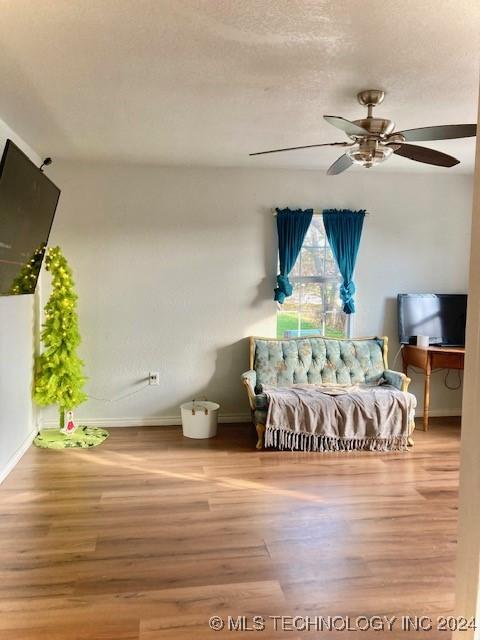 bedroom featuring hardwood / wood-style flooring, ceiling fan, and a textured ceiling