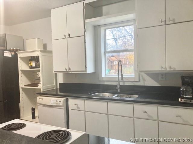 kitchen with white appliances, white cabinetry, and sink