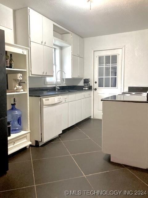 kitchen featuring white cabinets, dishwasher, dark tile patterned floors, and a textured ceiling