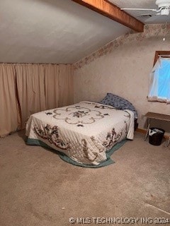 carpeted bedroom with beam ceiling