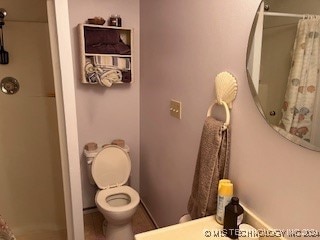 bathroom featuring toilet and a shower with curtain