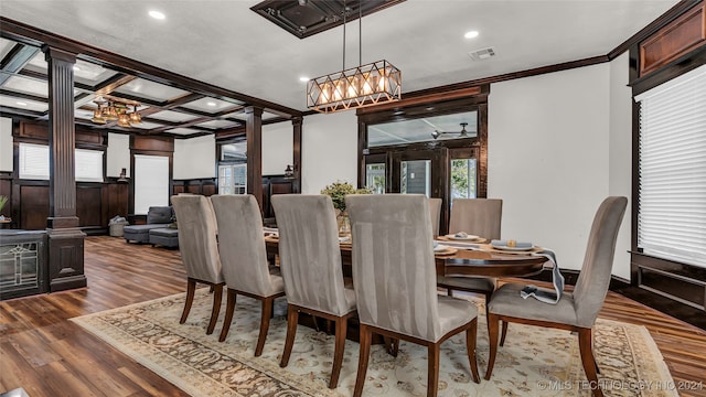 dining room with ornamental molding, dark hardwood / wood-style flooring, coffered ceiling, an inviting chandelier, and decorative columns