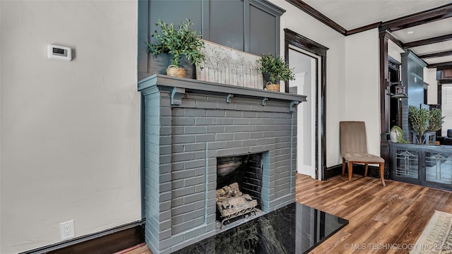 room details featuring hardwood / wood-style flooring, ornamental molding, and a brick fireplace