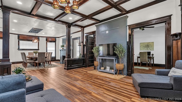 living room featuring coffered ceiling, hardwood / wood-style flooring, and ornate columns