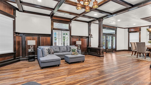 living room with light hardwood / wood-style floors, beam ceiling, coffered ceiling, and decorative columns