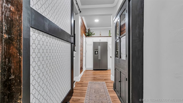 hall featuring light hardwood / wood-style flooring and crown molding