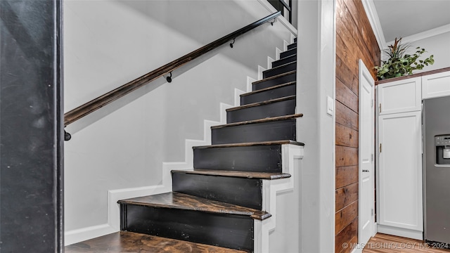 staircase featuring hardwood / wood-style flooring and crown molding