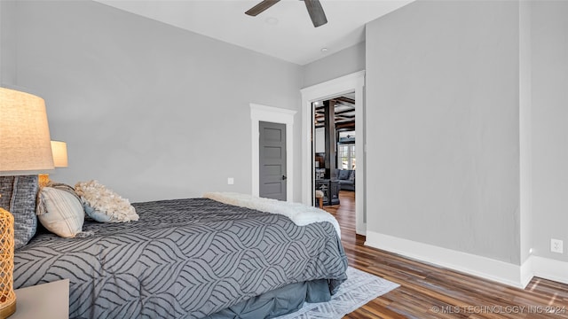 bedroom featuring dark hardwood / wood-style flooring, ceiling fan, and a closet