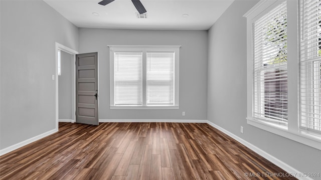 unfurnished room with ceiling fan and dark hardwood / wood-style flooring