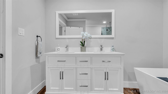 bathroom featuring hardwood / wood-style floors, vanity, a tub to relax in, and crown molding