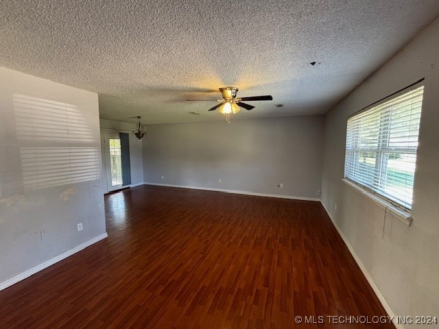 unfurnished room with ceiling fan, dark hardwood / wood-style floors, and a textured ceiling