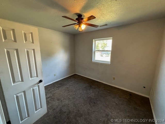 carpeted spare room featuring a textured ceiling and ceiling fan