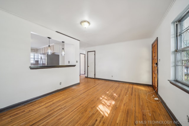 unfurnished living room featuring ornamental molding and wood-type flooring