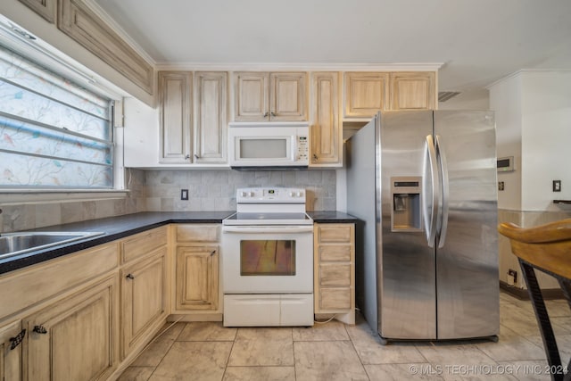 kitchen featuring light brown cabinetry, backsplash, and white appliances