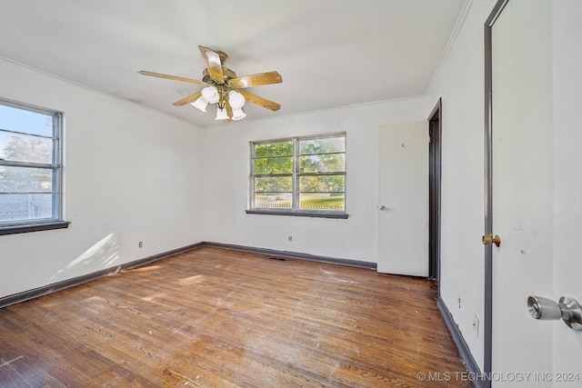 unfurnished bedroom featuring multiple windows, hardwood / wood-style floors, crown molding, and ceiling fan