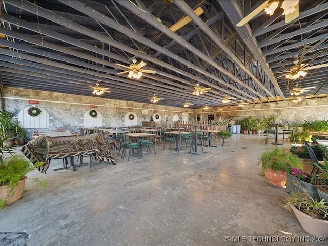 unfurnished dining area featuring ceiling fan and concrete floors