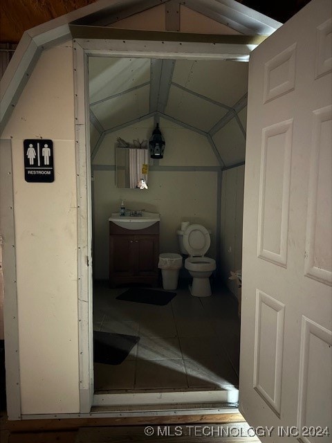 bathroom with vanity, toilet, and vaulted ceiling