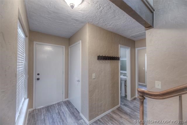 hall featuring hardwood / wood-style floors and a textured ceiling