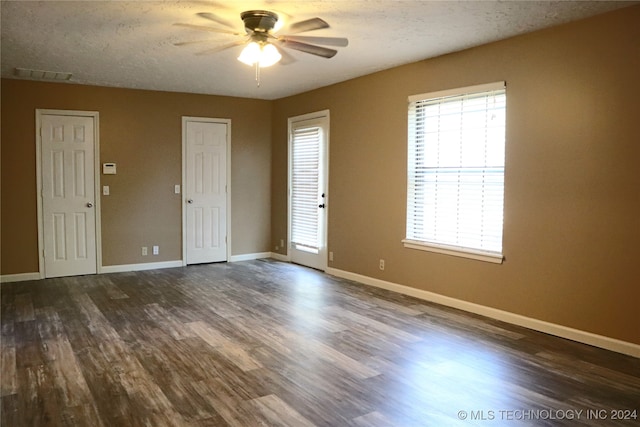 spare room featuring dark hardwood / wood-style flooring, a textured ceiling, and ceiling fan