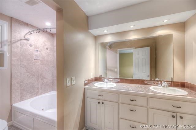 bathroom featuring tiled shower / bath and vanity