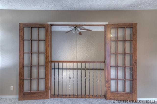 carpeted empty room featuring a textured ceiling and ceiling fan