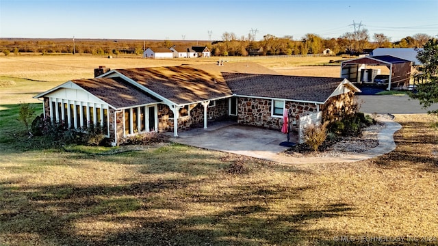 view of front of house featuring a front lawn and a rural view