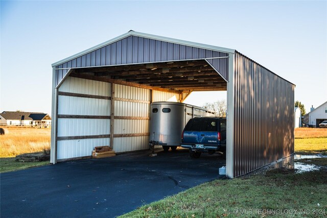 view of vehicle parking featuring water heater and a carport