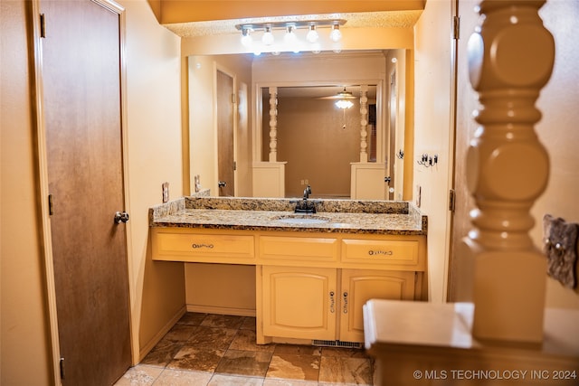 bathroom with ceiling fan, vanity, and baseboards