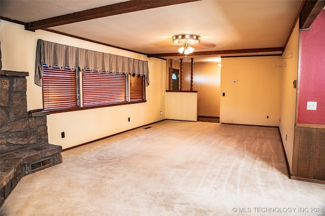 living room featuring a fireplace, beam ceiling, and carpet