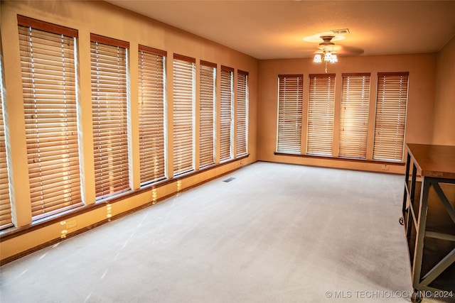 interior space featuring light carpet, baseboards, visible vents, and a ceiling fan