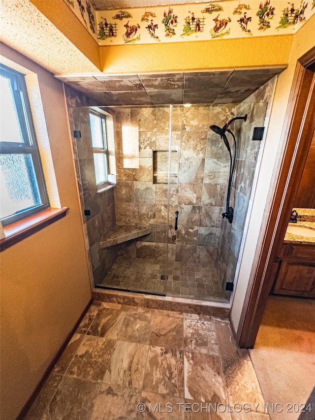 bathroom featuring a stall shower, vanity, and baseboards