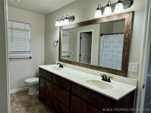 bathroom featuring toilet, vanity, and tile patterned flooring