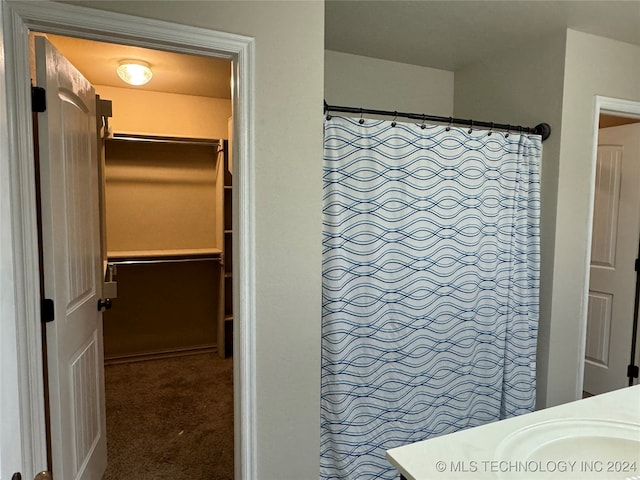 bathroom with curtained shower and vanity