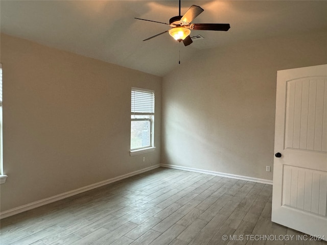 empty room with lofted ceiling, ceiling fan, and light hardwood / wood-style flooring