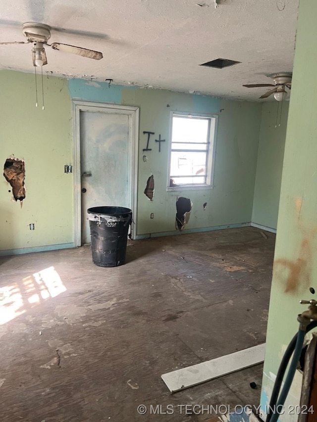 empty room with a textured ceiling and ceiling fan