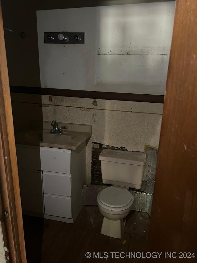 bathroom with toilet, vanity, and hardwood / wood-style flooring