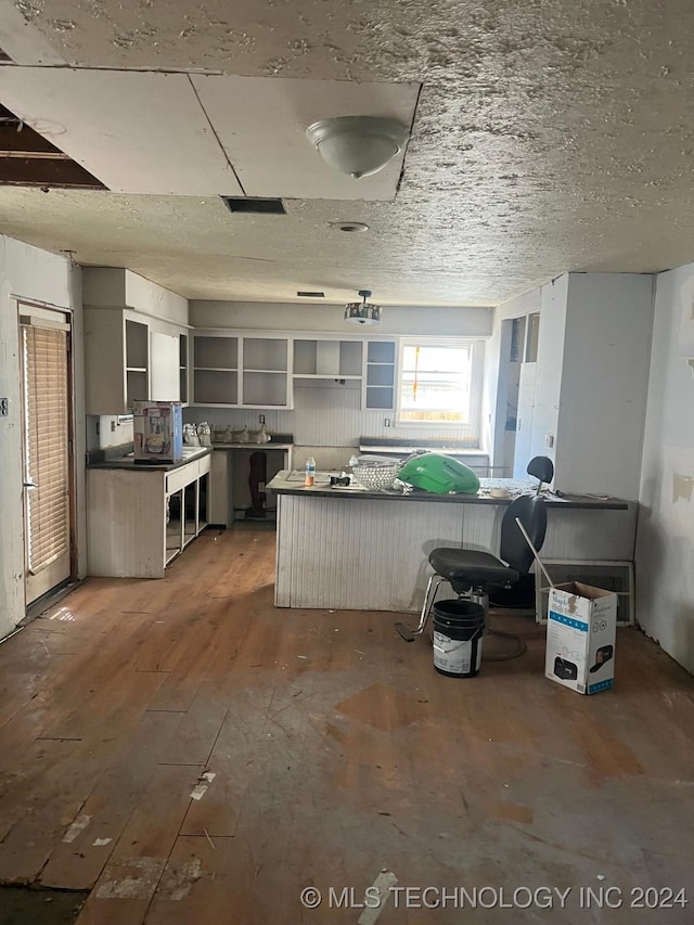 kitchen with kitchen peninsula and hardwood / wood-style flooring