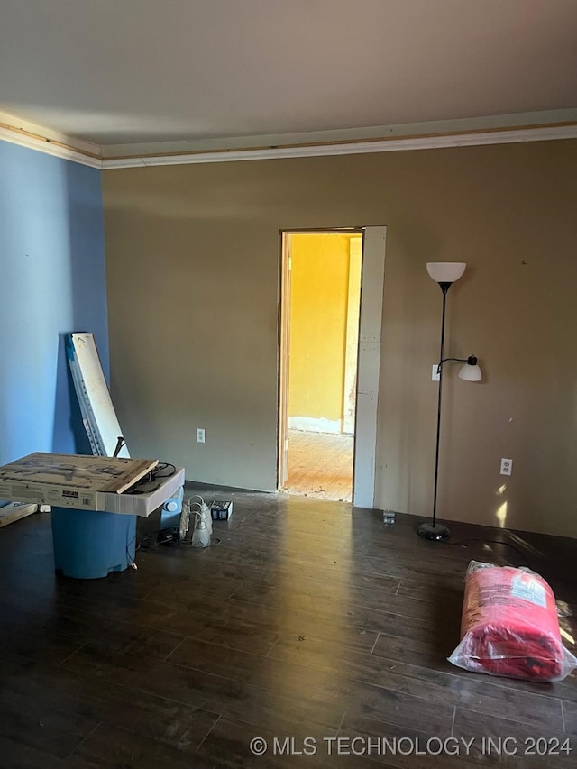 empty room featuring dark hardwood / wood-style flooring and crown molding