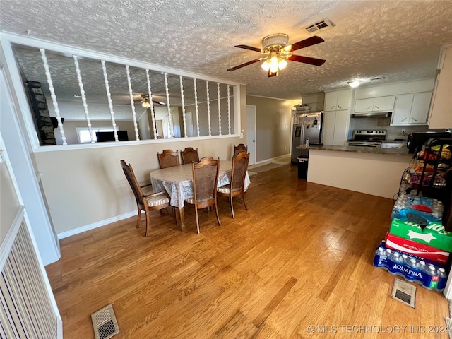 dining room with a textured ceiling, sink, ceiling fan, and light hardwood / wood-style flooring