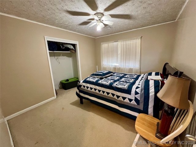 carpeted bedroom featuring a closet, a textured ceiling, ceiling fan, and crown molding