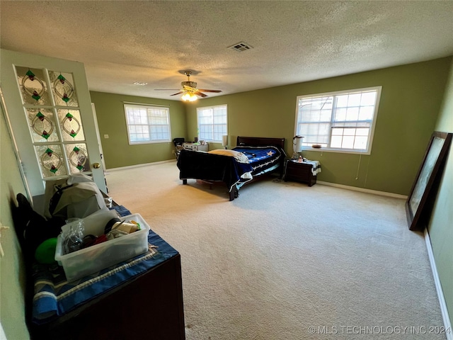 carpeted bedroom with a textured ceiling and ceiling fan