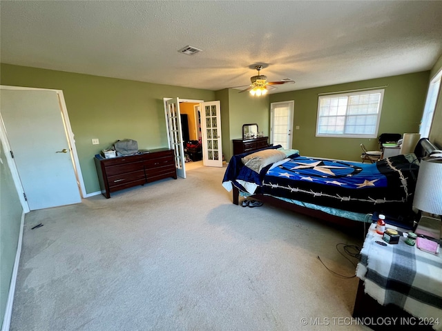 carpeted bedroom with a textured ceiling and ceiling fan