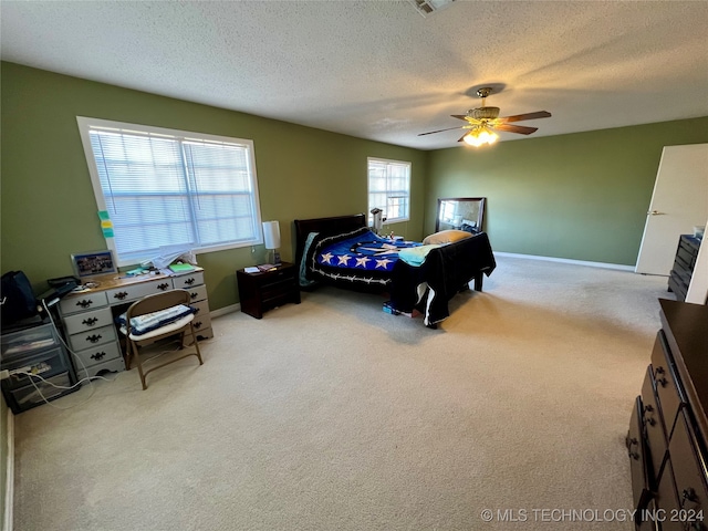 carpeted bedroom featuring a textured ceiling and ceiling fan