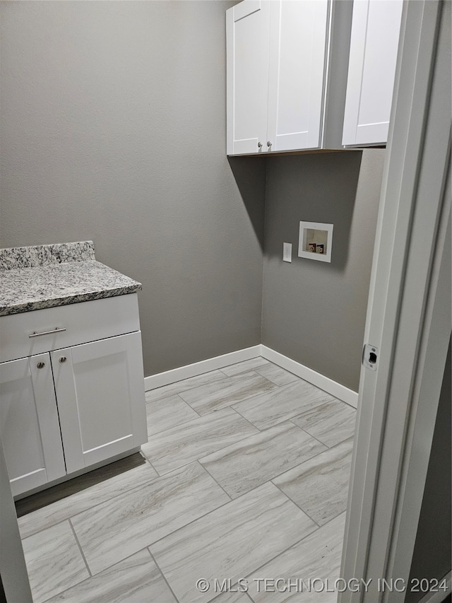 laundry area with hookup for a washing machine and cabinets