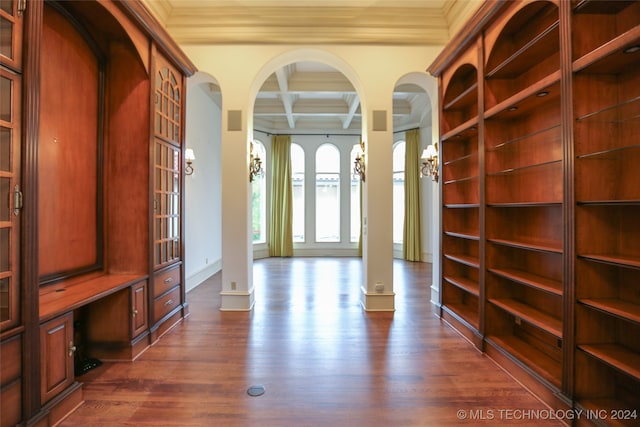 interior space featuring beamed ceiling, dark wood-type flooring, coffered ceiling, and ornamental molding