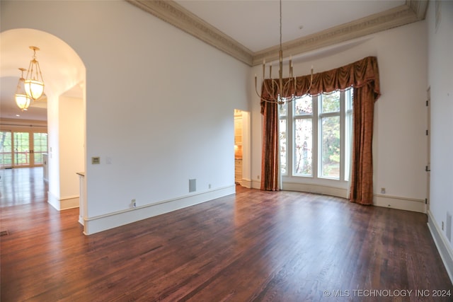 empty room with dark hardwood / wood-style floors and ornamental molding