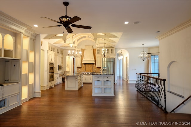 kitchen with appliances with stainless steel finishes, premium range hood, dark wood-type flooring, a center island, and hanging light fixtures