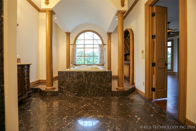 interior space with dark hardwood / wood-style floors, vaulted ceiling, crown molding, and decorative columns