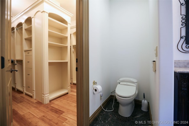 8403 S Allegheny Ave, Tulsa, OK 74137 - bathroom with toilet, wood finished floors, a spacious closet, and baseboards